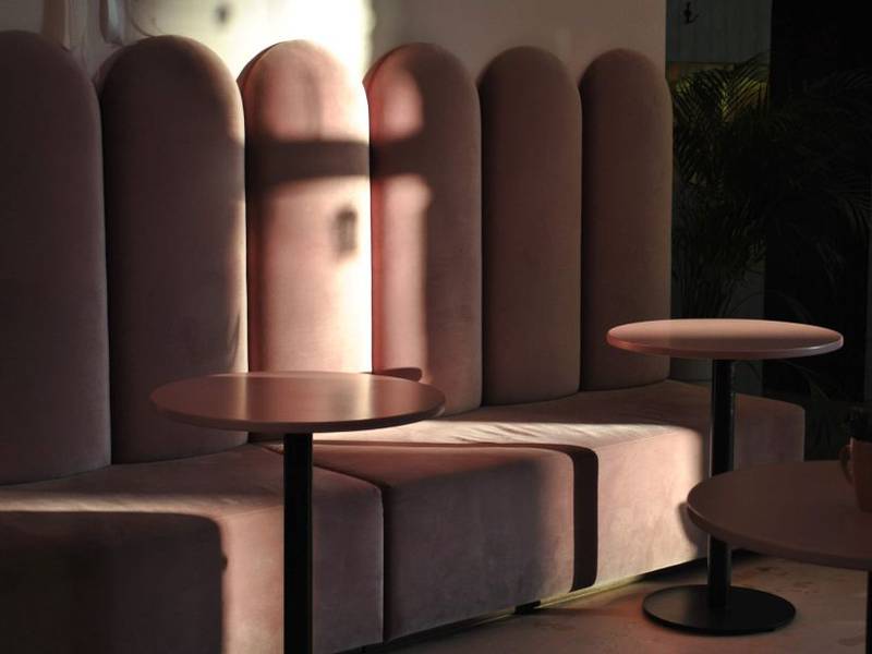 Pink scalloped booth seating inside a pastel café