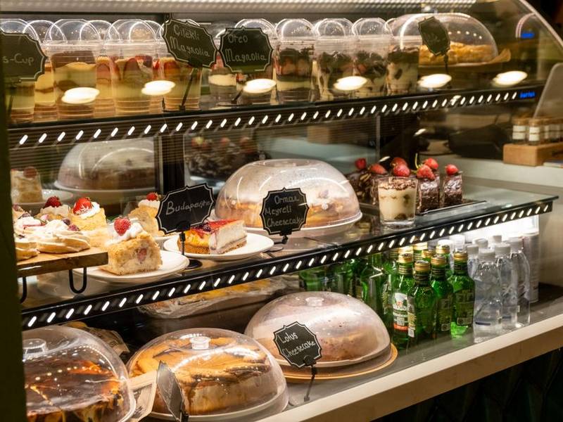 Glass display counter filled with cakes and pastries