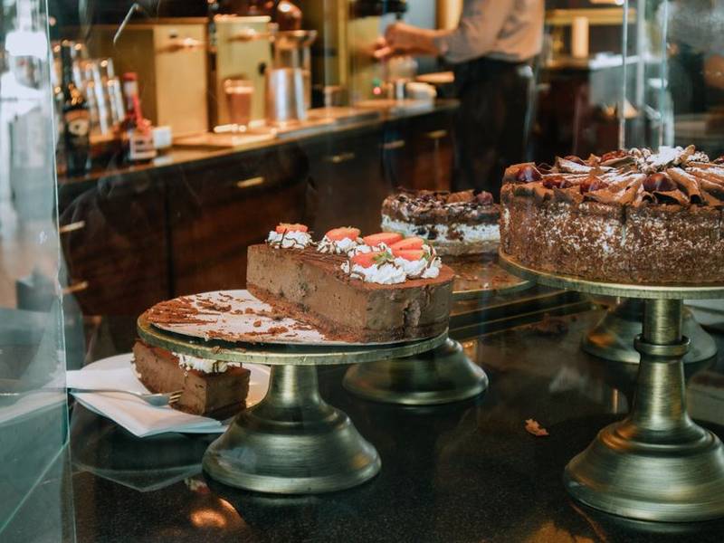 Cakes displayed on tiered stands at a bakery counter