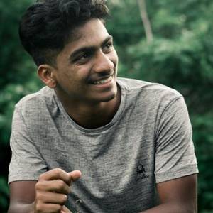 Young Indian man in a grey T-shirt smiling