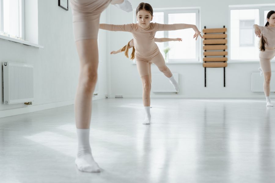 Young children practising dance steps together in a bright studio