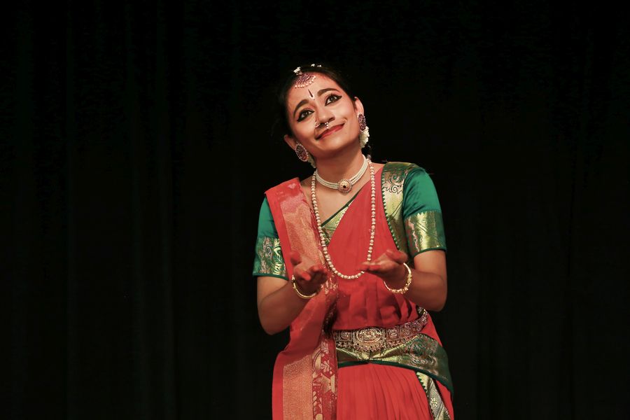 A Kathak dancer in expressive pose during a stage performance