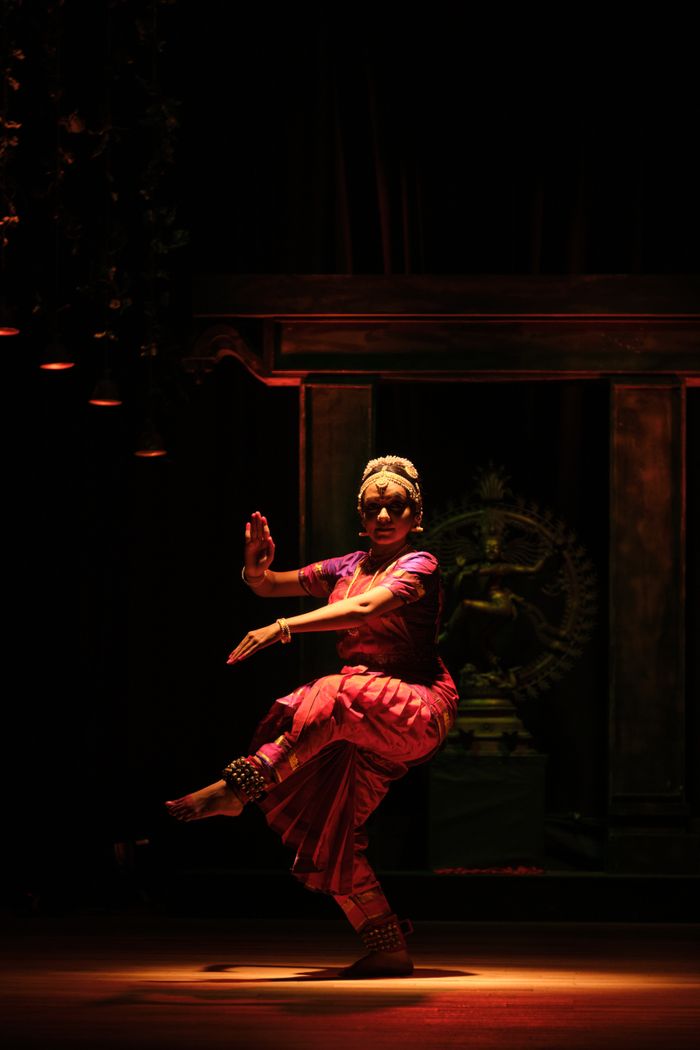 Guru Meghna Pillai performing in a dim temple setting