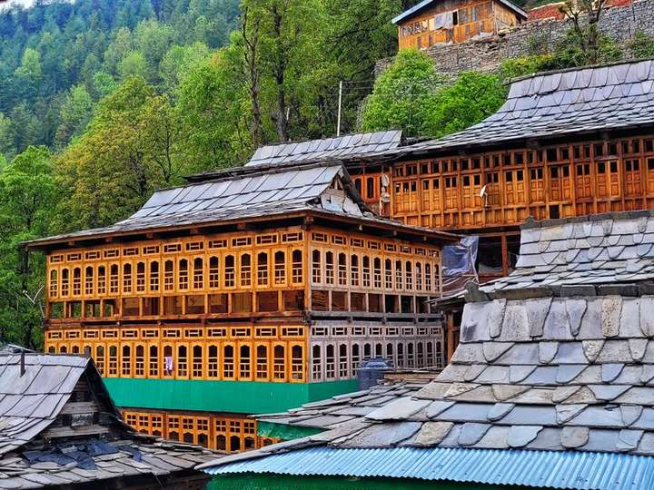 Traditional timber and slate house with carved balconies in the Kullu valley