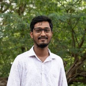 Smiling Indian man in a white shirt and glasses