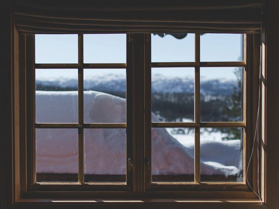 Wooden window frame looking out at snow-covered mountains