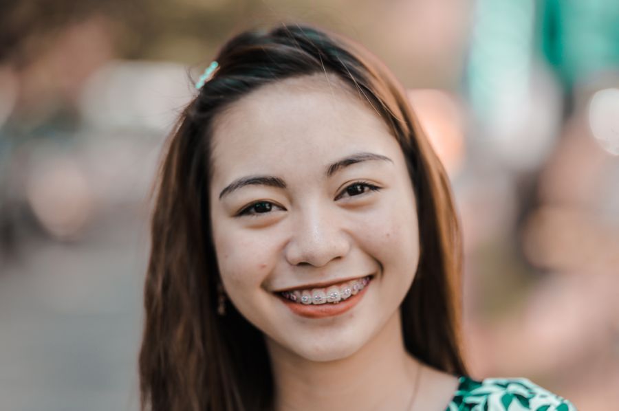A young woman smiling confidently with her braces