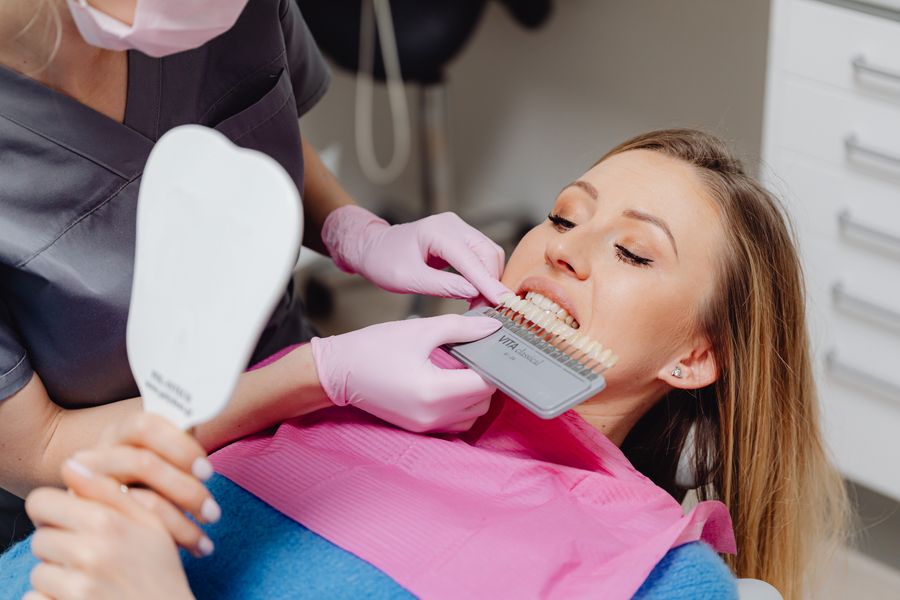 A shade guide being matched against a patient's teeth before whitening