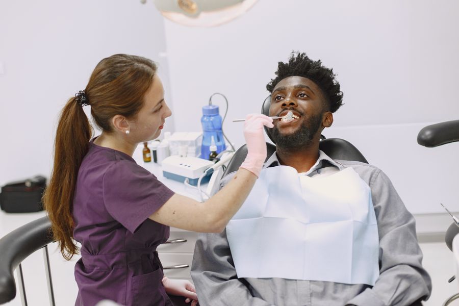 A dentist gently examining a patient during a routine check-up