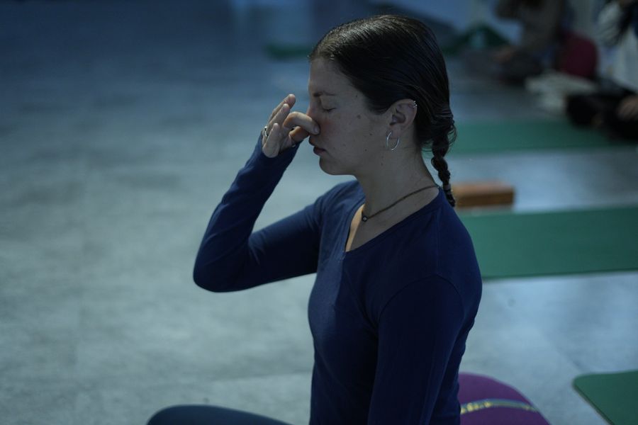 A student seated in pranayama practice, hands resting in mudra