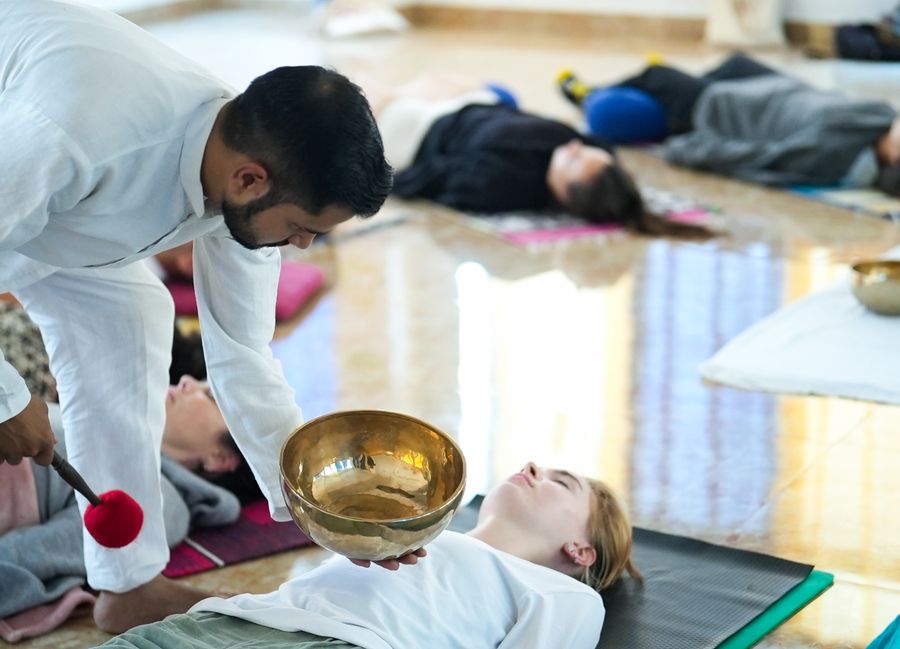 A sound healing session with Himalayan singing bowls arranged on the floor