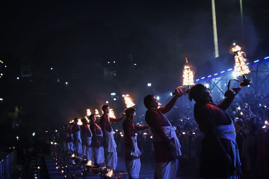 Evening Ganga aarti with lamps and crowds at Triveni Ghat