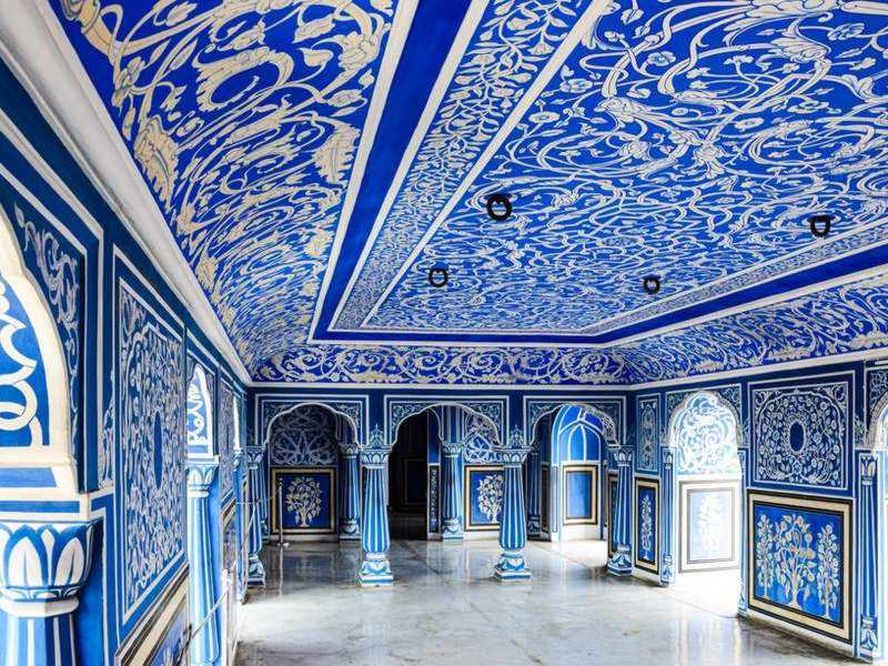 Painted arches and pillars inside a Jaipur palace hall
