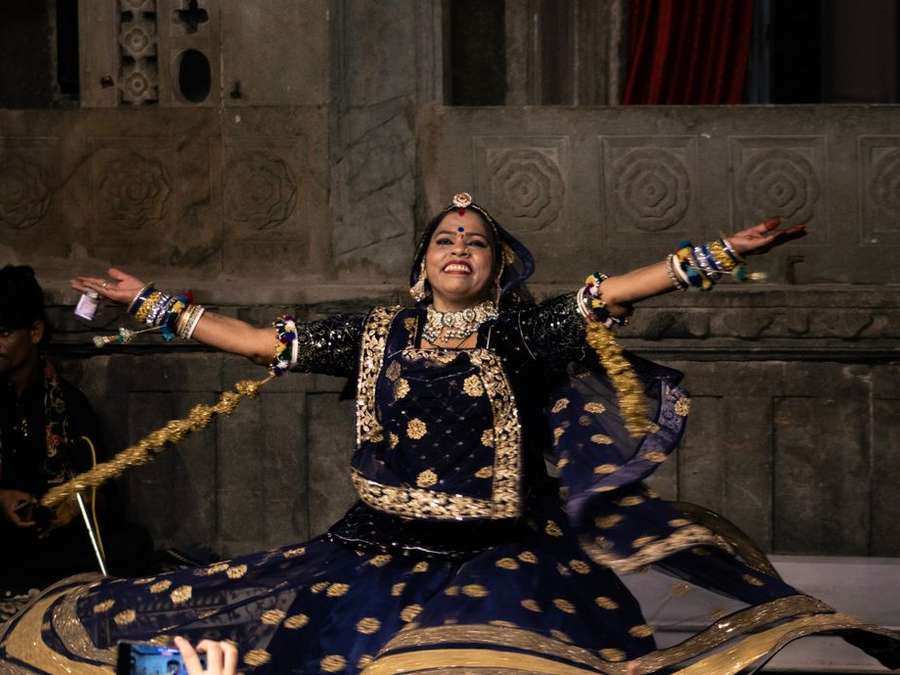 Rajasthani folk dancer in a swirling embroidered skirt performing in a courtyard