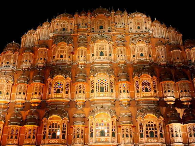 The honeycomb facade of Hawa Mahal in Jaipur lit golden at night