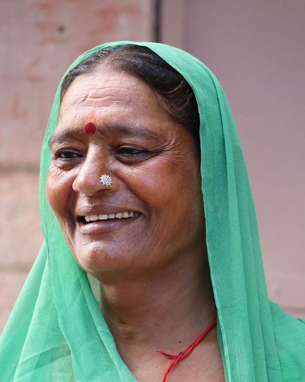 Smiling elderly Indian woman in a green bandhani odhni