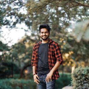 Smiling young Indian man outdoors in a checked shirt