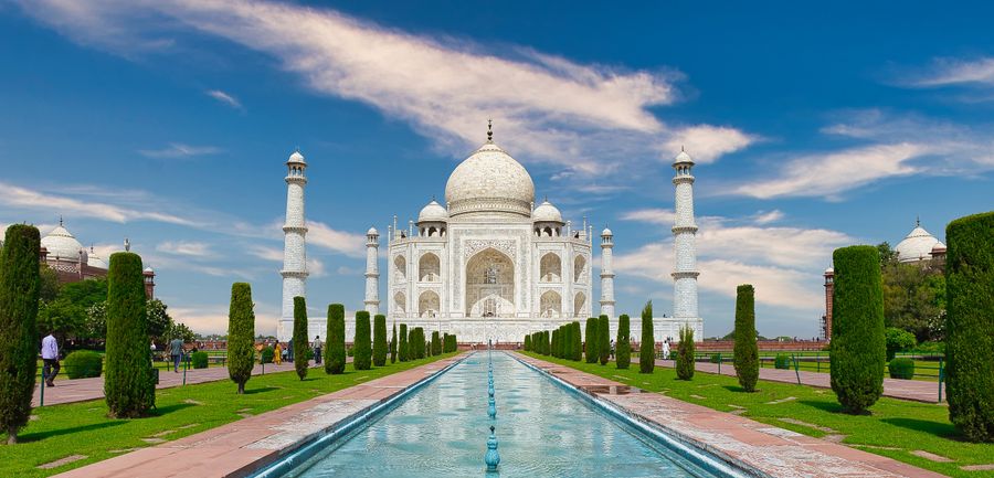 The Taj Mahal reflected in its long pool under a clear sky