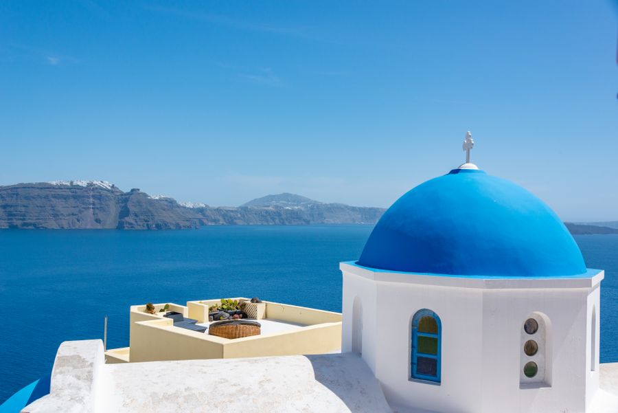 A blue-domed church overlooking the Aegean Sea in Santorini
