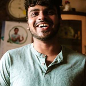 Laughing young Indian man in a green t-shirt