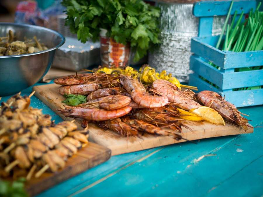 Grilled seafood platter with prawns and fish on a blue beach table