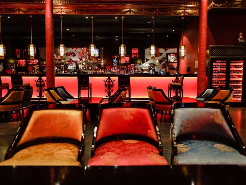 Restaurant lounge bathed in red light with low seating