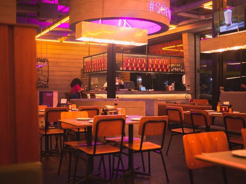 Restaurant interior with neon lights and bar seating at night