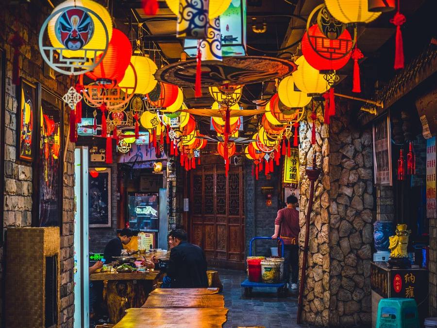 Red Chinese lanterns glowing above a restaurant street at night