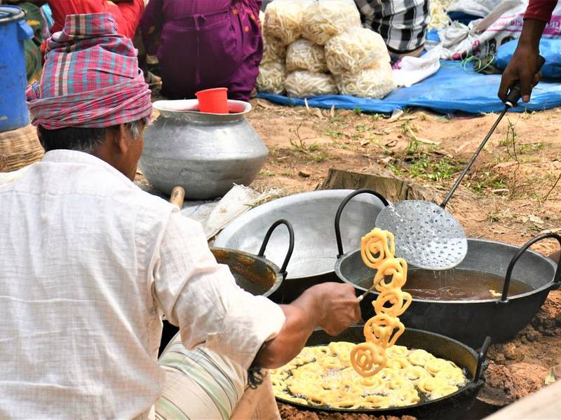 Halwai frying jalebis in a large kadhai at a street stall