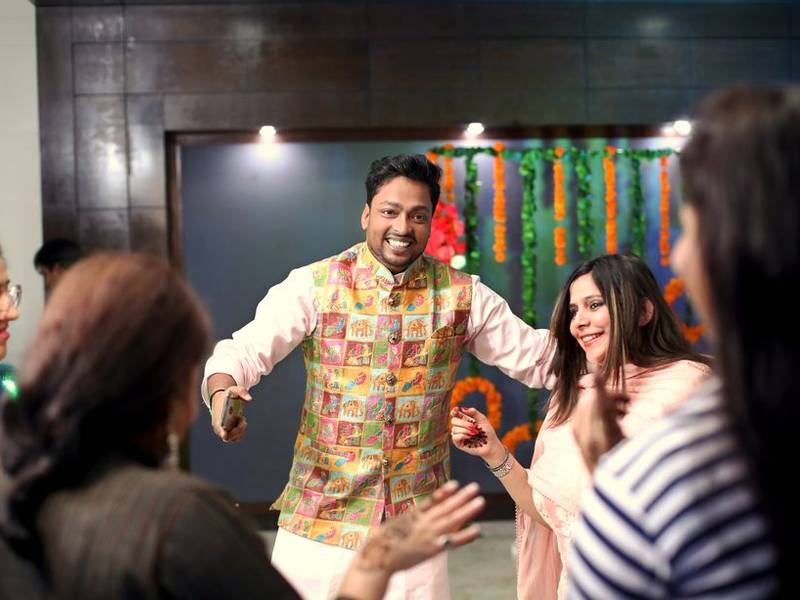 Indian friends dancing and laughing at a party on the terrace