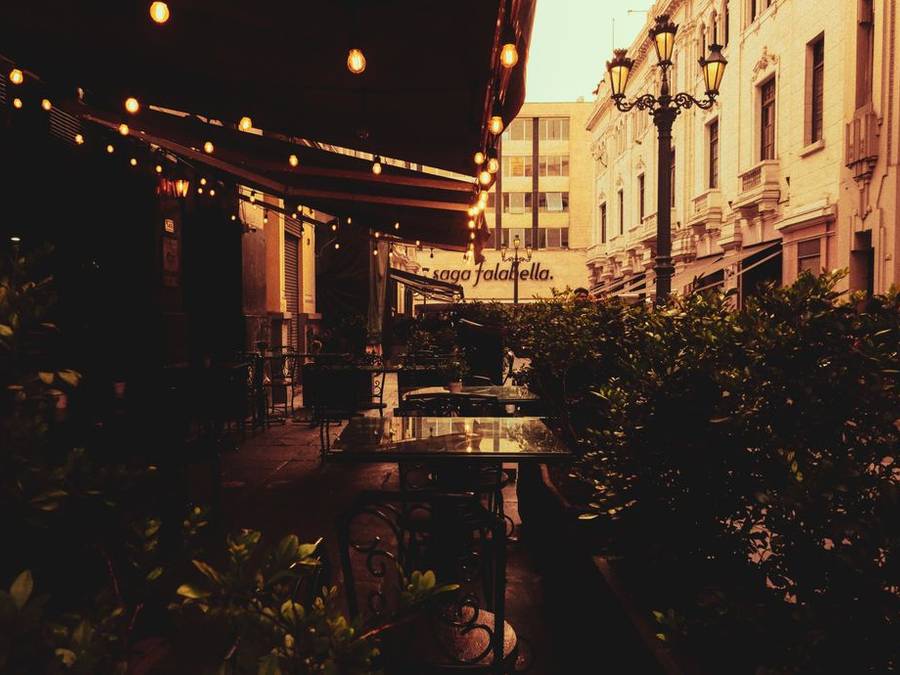 Terrace café at night lit by strings of warm lights