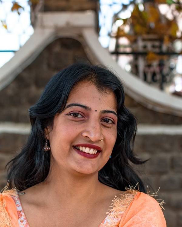 Smiling Indian woman in a green and gold dupatta