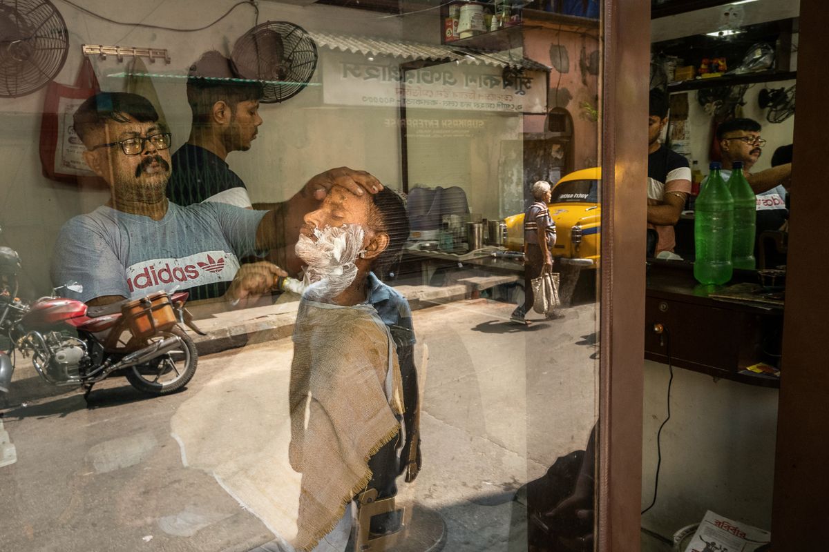 A barber at work seen through the window of a heritage barbershop