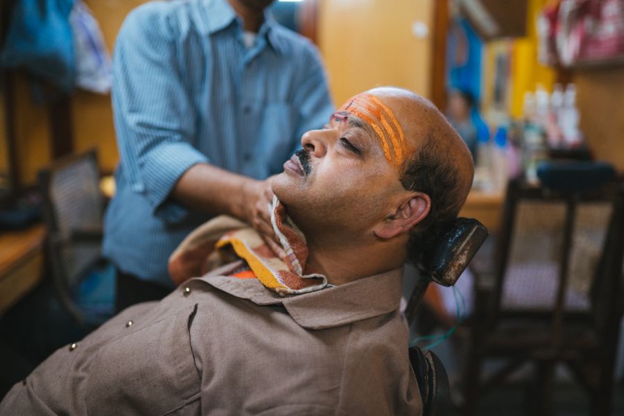A customer receiving a traditional head massage at the barbershop