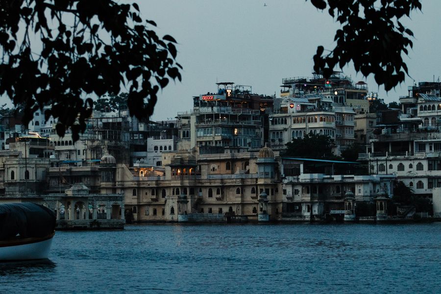 Udaipur's City Palace glowing across Lake Pichola at dusk