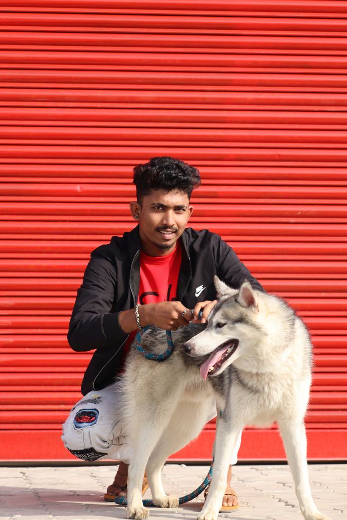 Rohan Kulkarni standing beside a Siberian Husky